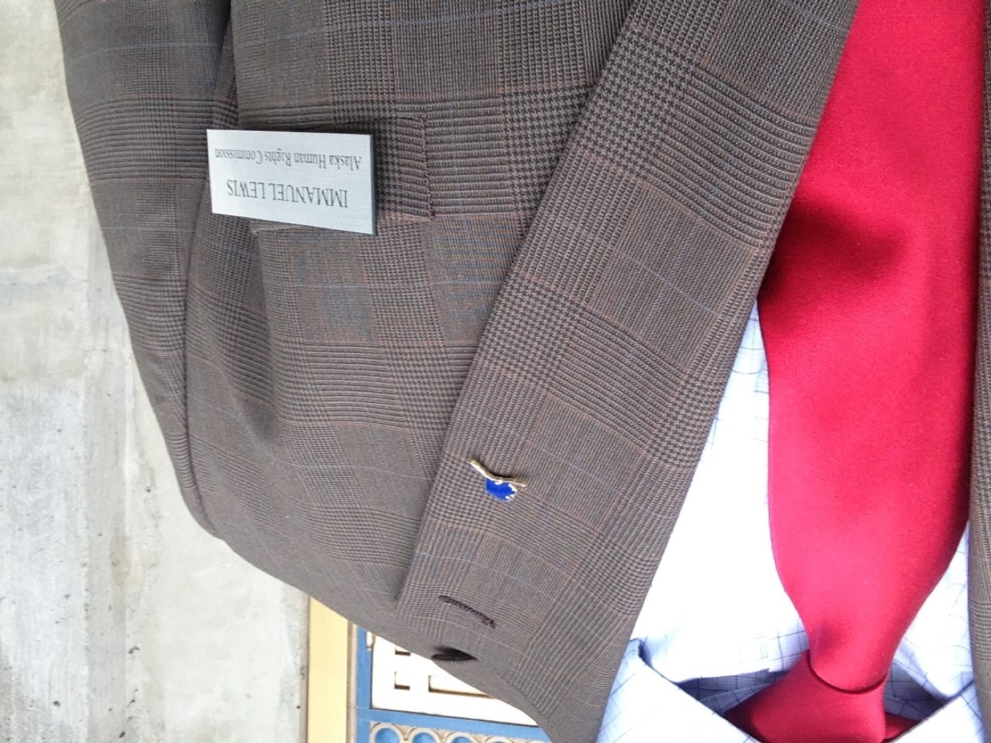 Alaska Human Rights Commission name badge on Manny's suit jacket